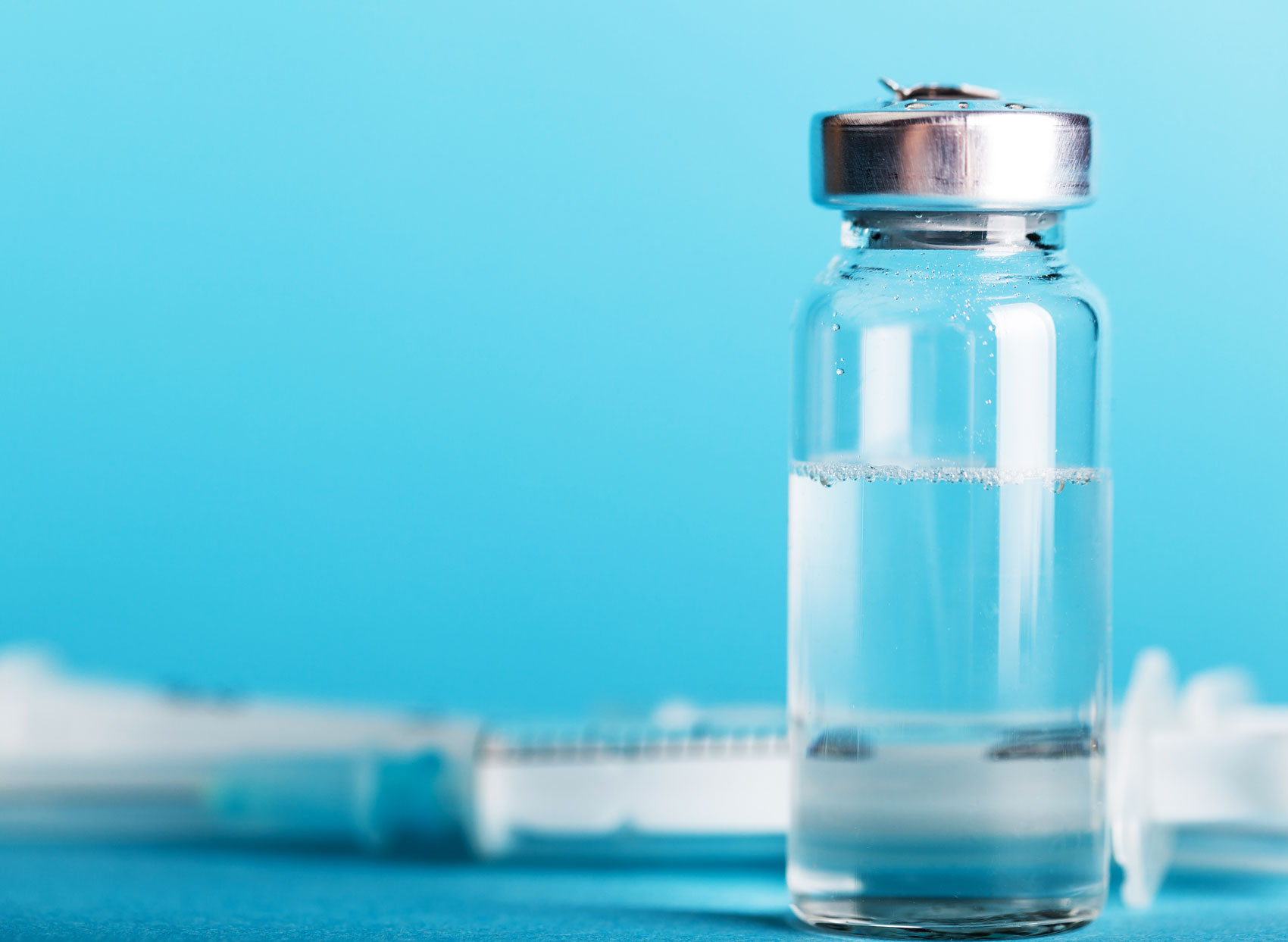boccetta con vaccino su sfondo azzurro