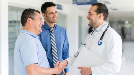 medico stringe la mano a un paziente accompagnato