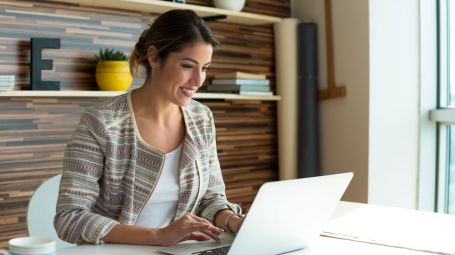 donna sorridente alla scrivania con computer