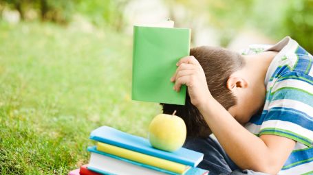 dislessia bambino nasconde testa in un libro