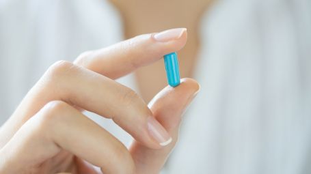 mano di donna con capsula azzurra