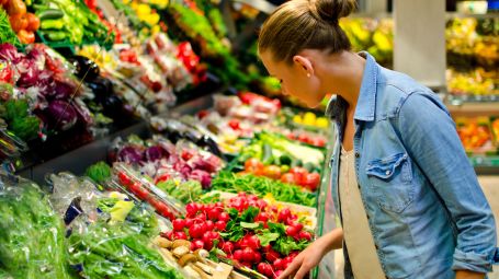 donna davanti al banco di frutta e verdura