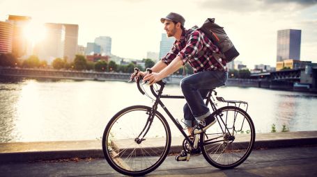 uomo giovane con zaino, in bicicletta