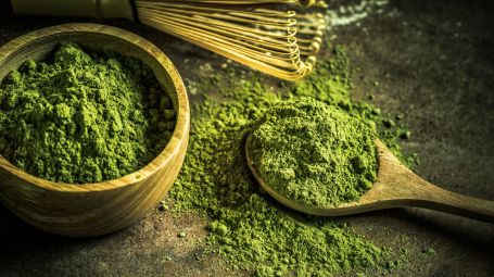 polvere verde di tè matcha su cucchiaio di legno