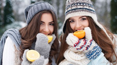 ragazze mangiano arance in montagna