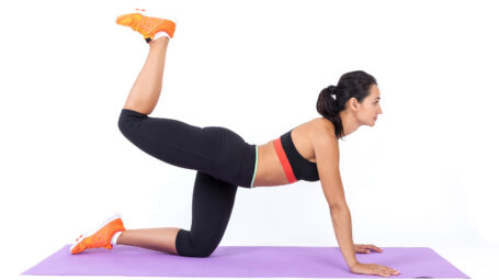 ragazza su tappetino fa allenamento, stretching, esercizi di slanci posteriori
