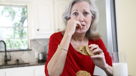 donna matura mangia biscotti e latte