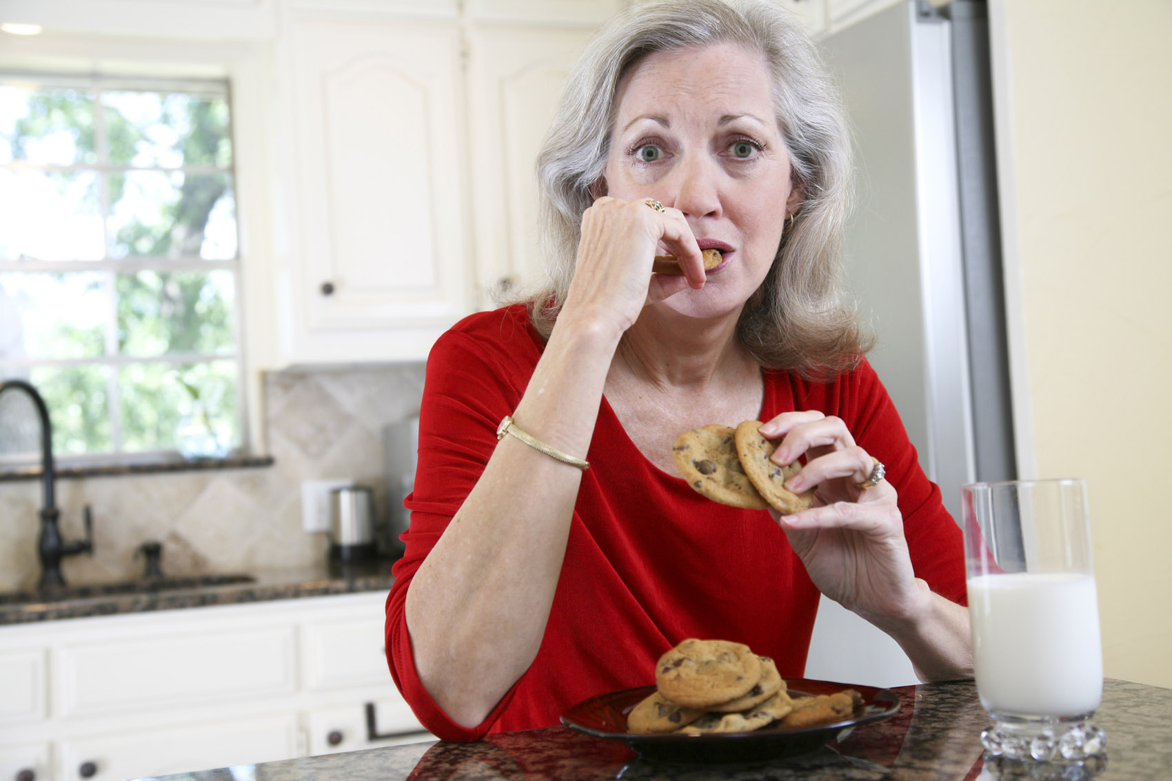 donna matura mangia biscotti e latte