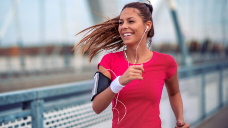 donna sorridente fa jogging, corsa, runner, cuffiette