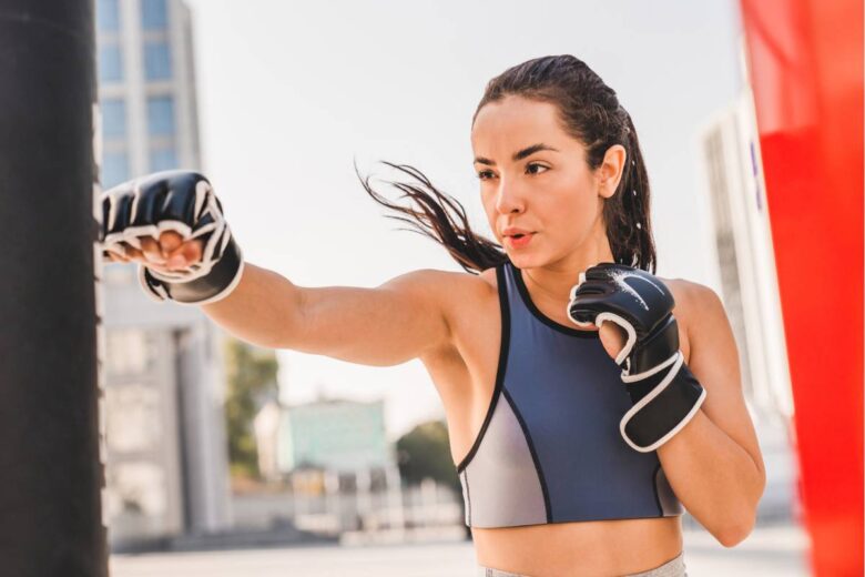 Ragazza tira un pugno a un sacco da fitboxing