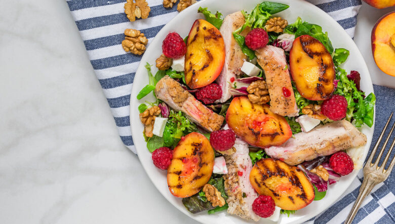 Insalata di pollo alla griglia con pesche, lamponi, noci e verdure miste grigliate