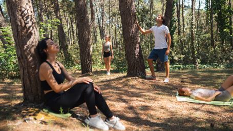 wellbeing: persone si rilassa e fanno yoga in una pineta