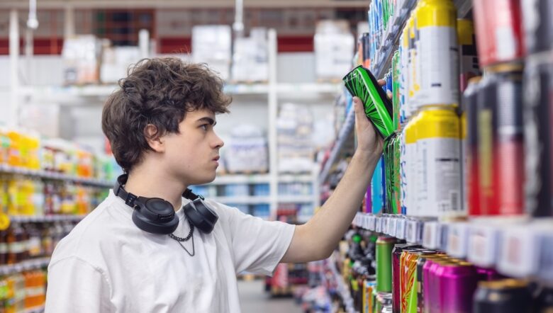 Adolescente prende un energy drink da uno scaffale