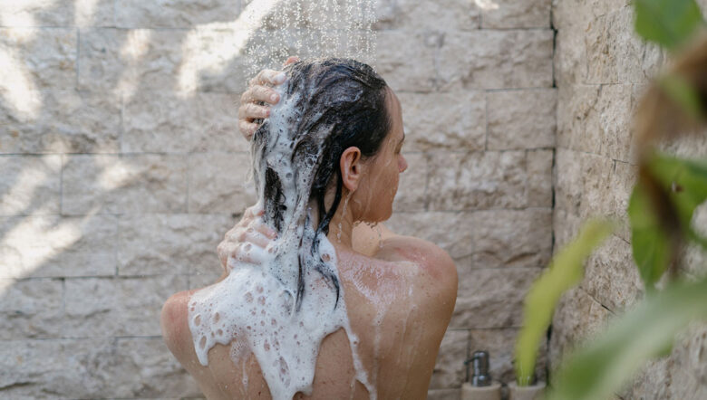 ragazza si lava i capelli d'estate