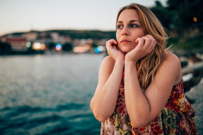 Una ragazza guarda il mare con tristezza