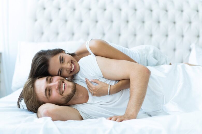 Giovane coppia a letto sorridente