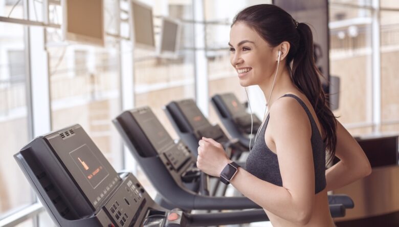 Ragazza corre sul tapis roulant in palestra