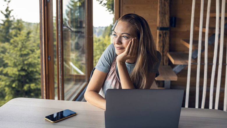ragazza guarda attraverso la finestra con il computer acceso