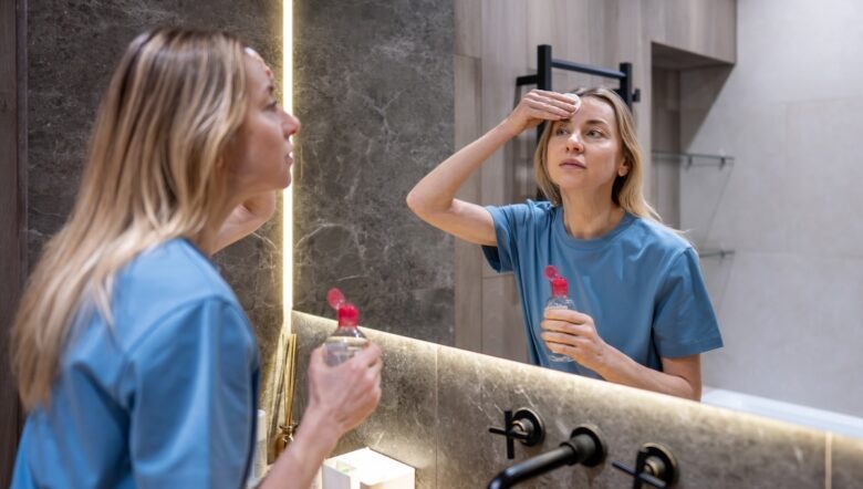 donna si strucca allo specchio acqua micellare