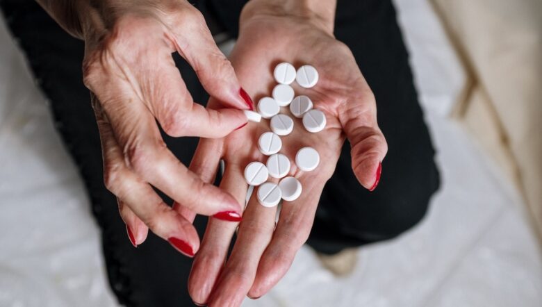 Mani di una donna anziana tengono delle pastiglie