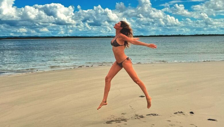 Gisele Bundchen (IG) salta su una spiaggia in costume