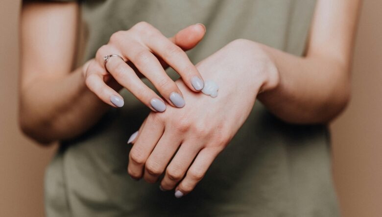 mani di donna mentre viene applicata una crema