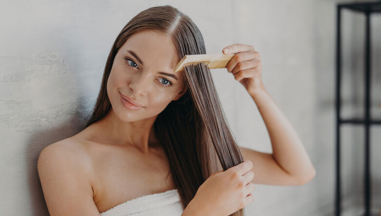 giovane donna bruna spazzola i capelli con il pettine