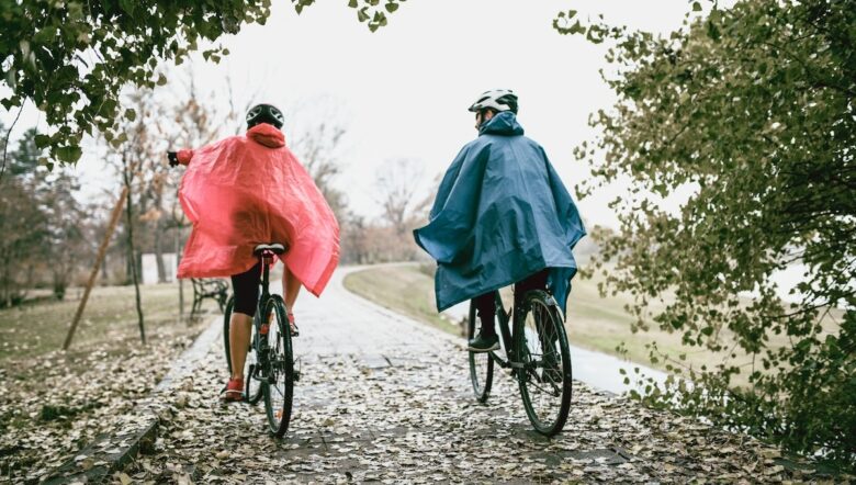 Due persone in bici sotto la pioggia