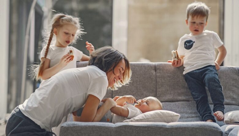 mamma gioca sul divano coi tre figli