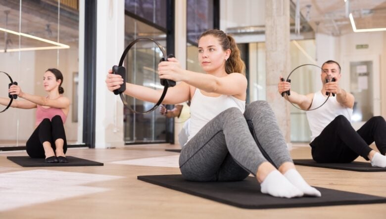 Persona che fanno pilates sul tappetino con i cerchi
