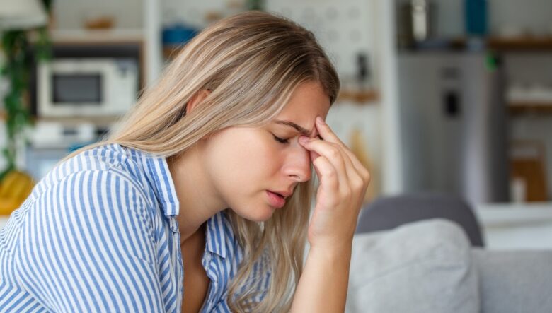 Ragazza con mal di testa tra le sopracciglia